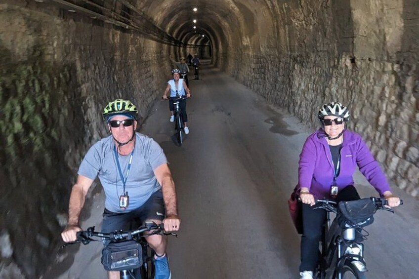 Radfahrer fahren durch einen Steintunnel. 3