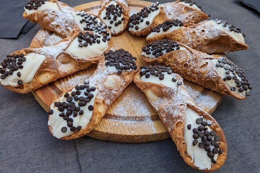 Ein Holzbrett mit verschiedenen Backwaren, einige mit Schokoladenstückchen und Puderzucker bestreut. 2