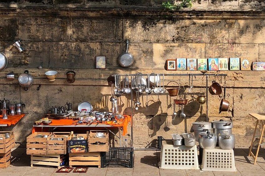 A market stall with various kitchen utensils and cookware. 4