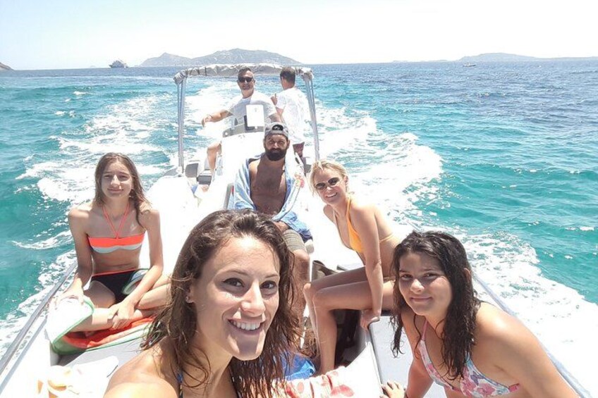 Eine Gruppe von Menschen auf einem Boot im Ozean, mit klarem, blauem Wasser und weiter Küste. 5