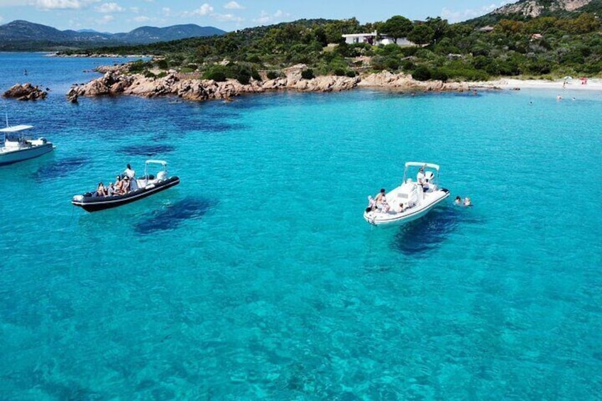 Un mar turquesa con barcos y un litoral rocoso. 4