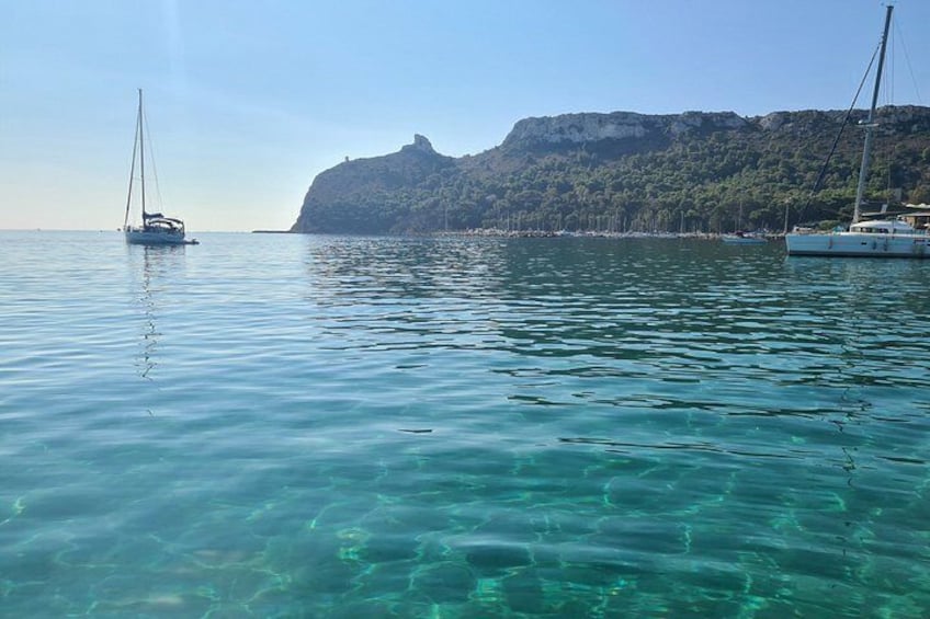 Mar tranquila con dos veleros, agua cristalina y una costa montañosa. 2