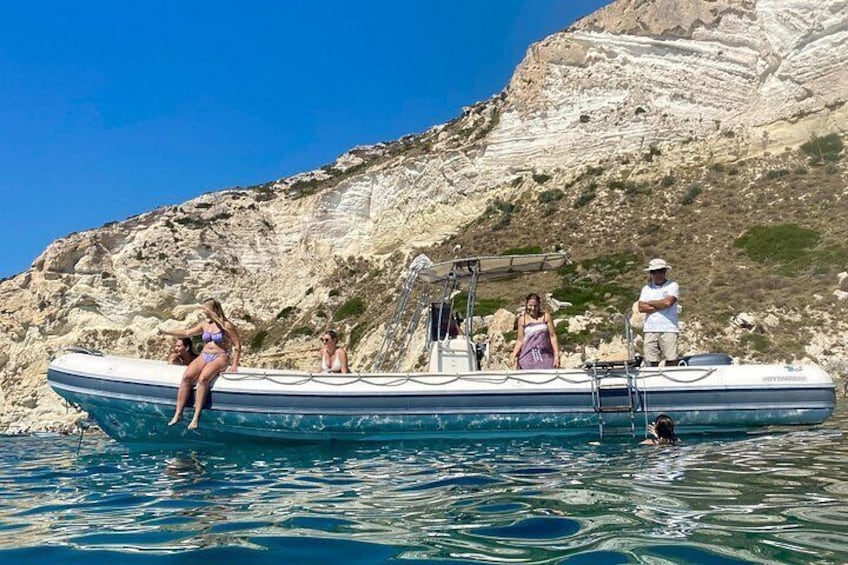Una embarcación con gente en una costa rocosa. 4