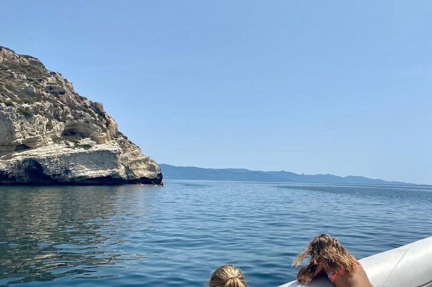 Una costa rocosa con agua tranquila, cielo despejado y un horizonte lejano. 3