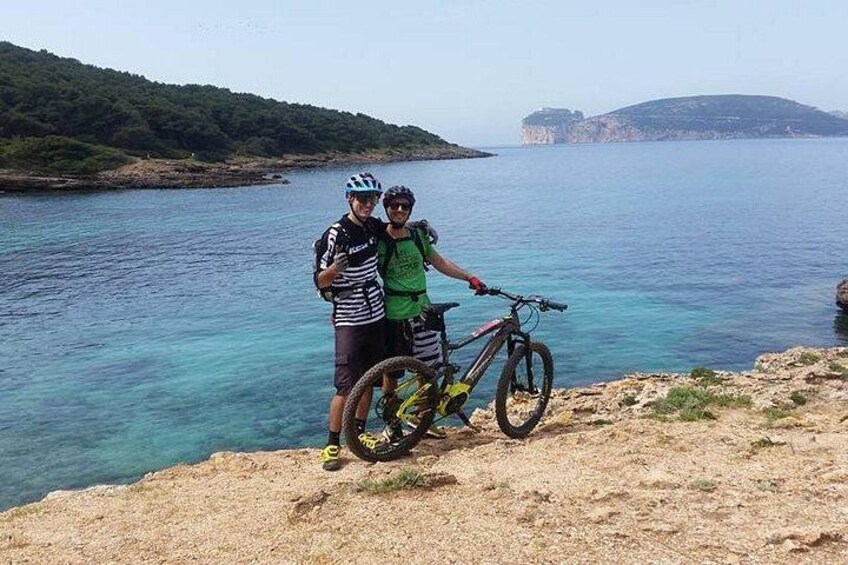 Dos personas de pie junto a un cuerpo de agua, con una montaña al fondo. 2