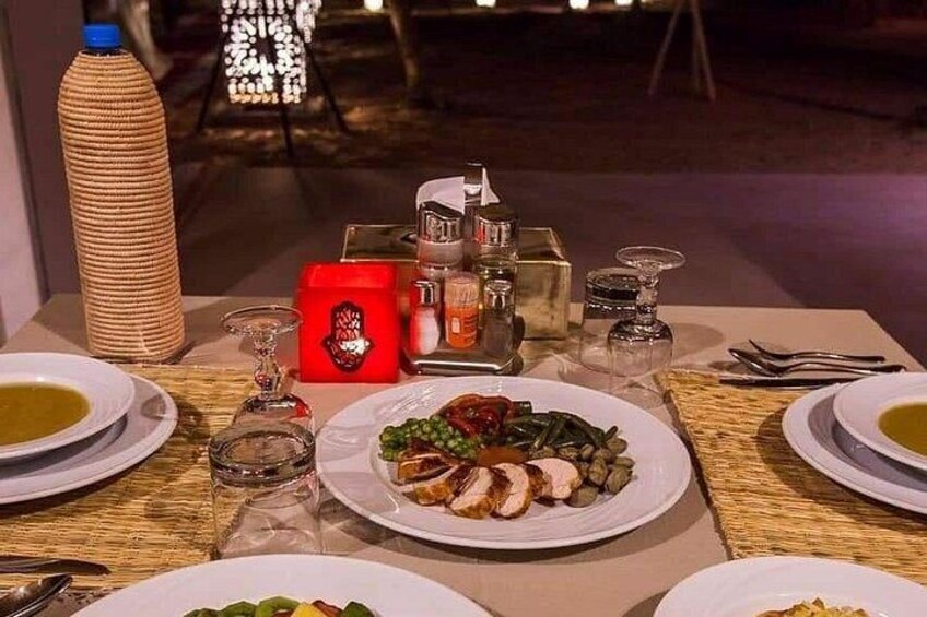 A table set for a meal with plates of food, a bottle, and a decorative candle. 3