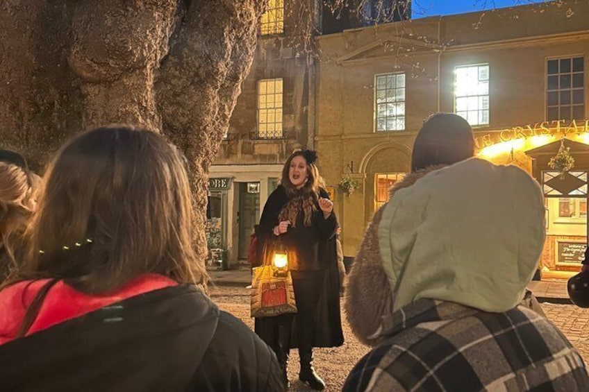 A person speaking to an audience in front of a building with a sign that reads 'THE CRYSTAL.' 5