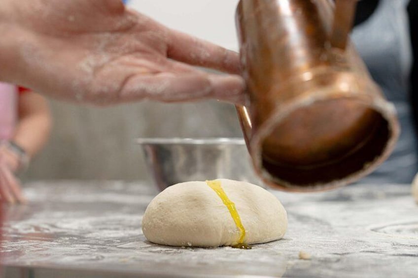Putting virgin oil on the dough. 2