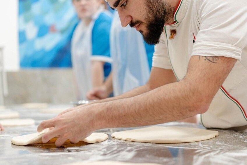 A person kneading dough on a marble surface. 3