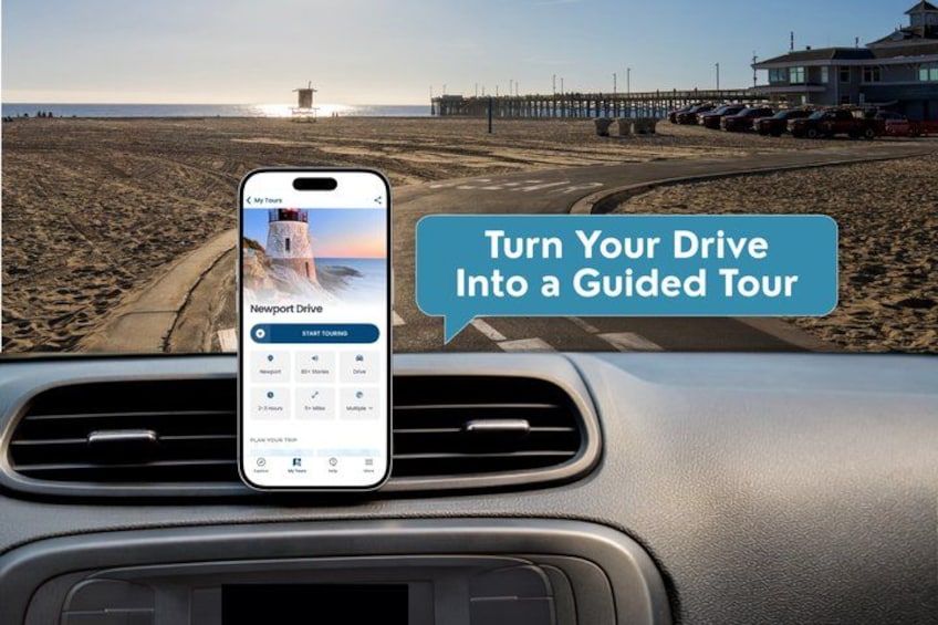 Ein Smartphone, das auf einem Autodashboard befestigt ist und eine geführte Touren-App anzeigt, mit Strand und Steg im Hintergrund. 1