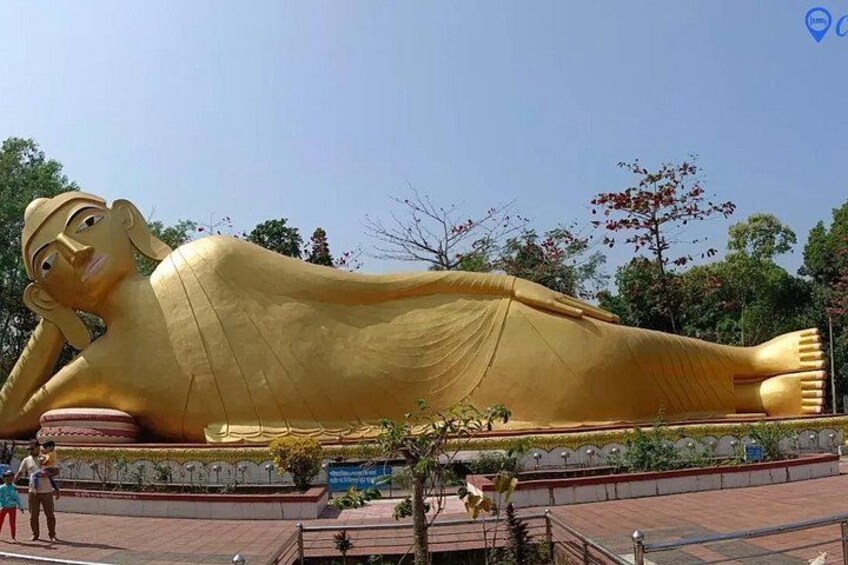 A large golden reclining Buddha statue outdoors. 3
