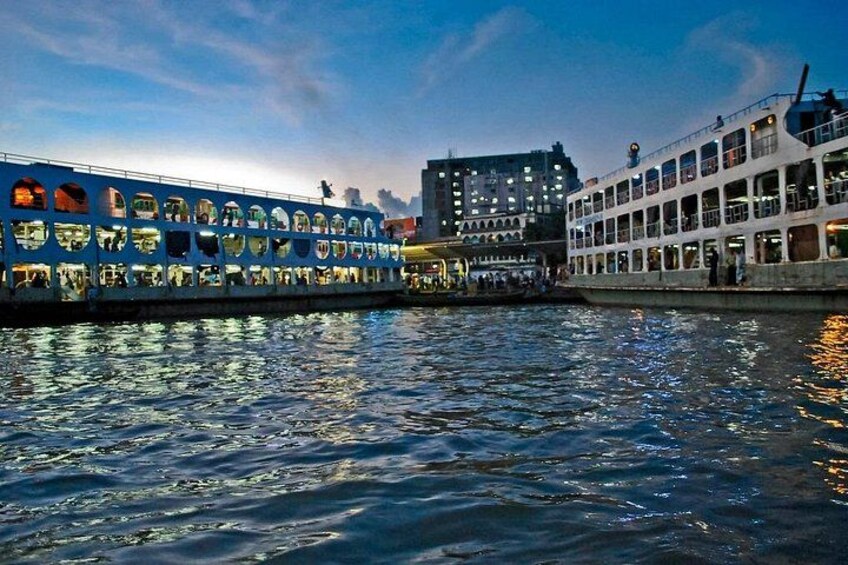 A river with a blue boat and a white boat docked at the pier. 5