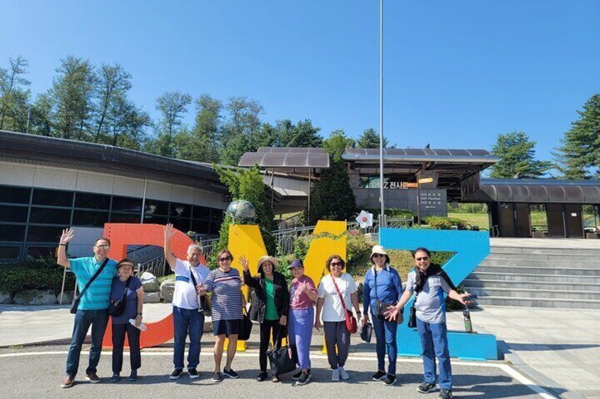 Un grupo de personas de pie frente a un edificio con formas geométricas coloridas. 1