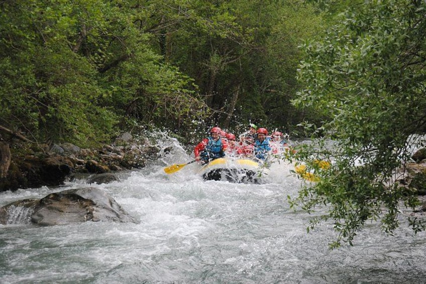 Un grupo de personas hacen rafting por un río rodeado de vegetación densa. 2