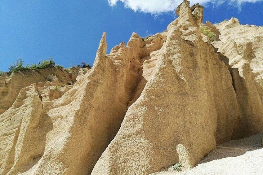 A desert landscape with prominent sand formations and sparse vegetation. 2