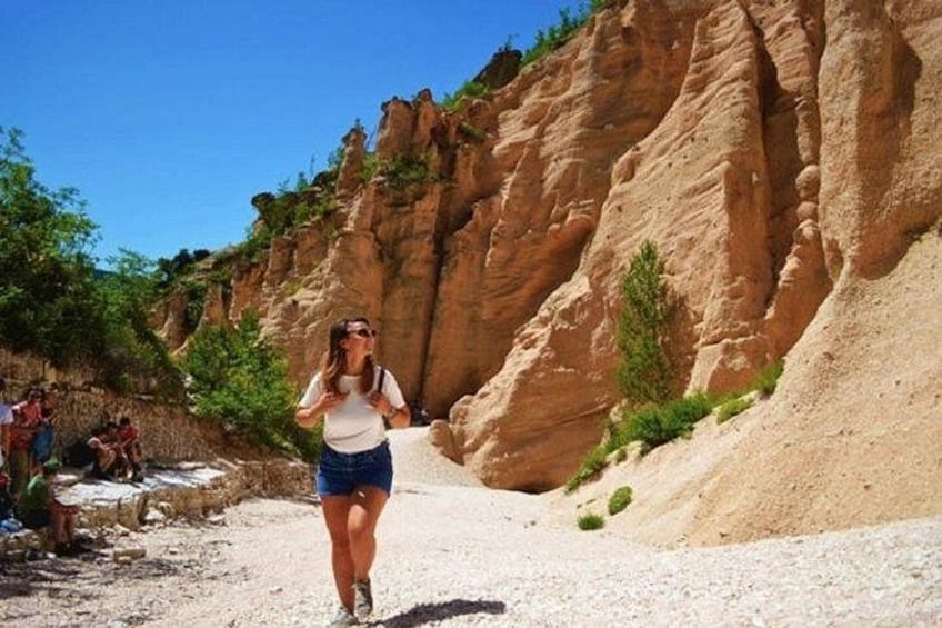 A person walking on a rocky path with a mountainous backdrop. 1