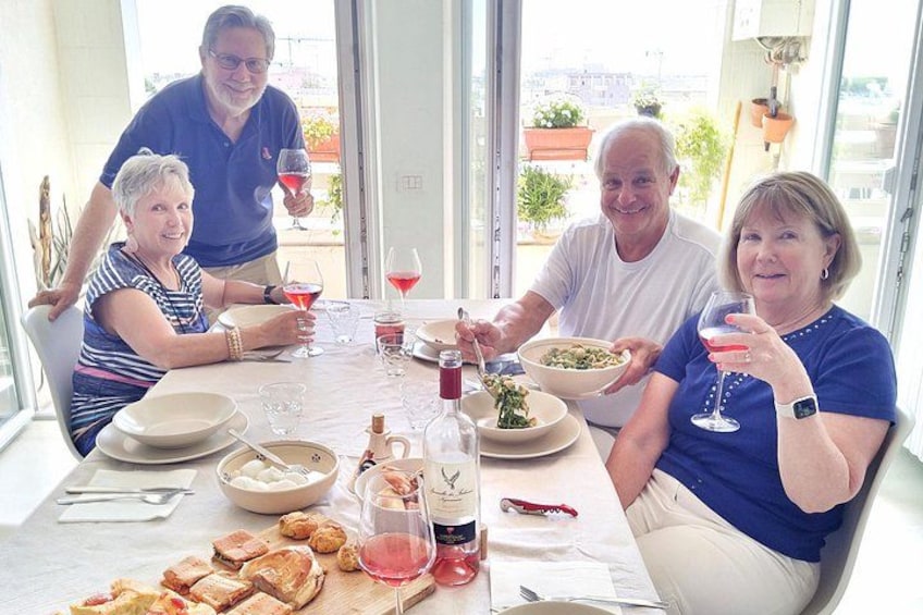 Un gruppo di persone che cena a tavola, con cibo e bevande. 2