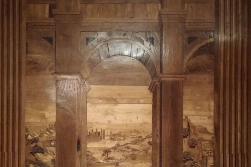 A wooden archway with a mural of a historical battle scene. 2