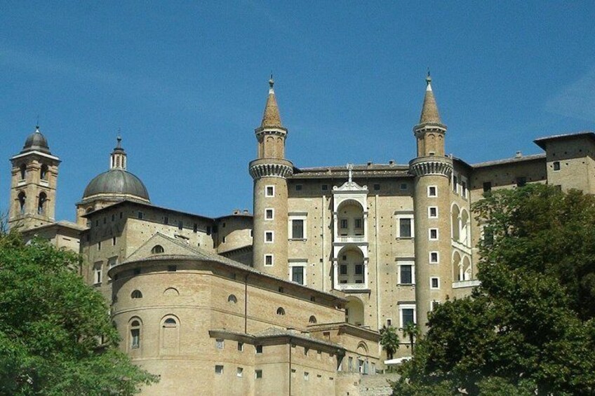 A historic building with multiple towers and domes, surrounded by trees. 5