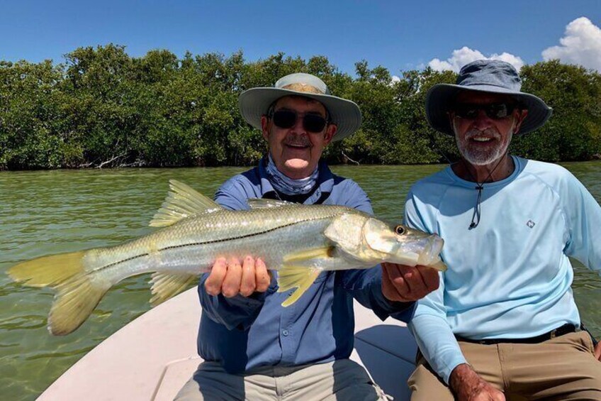 Two people on a boat holding a fish. 3