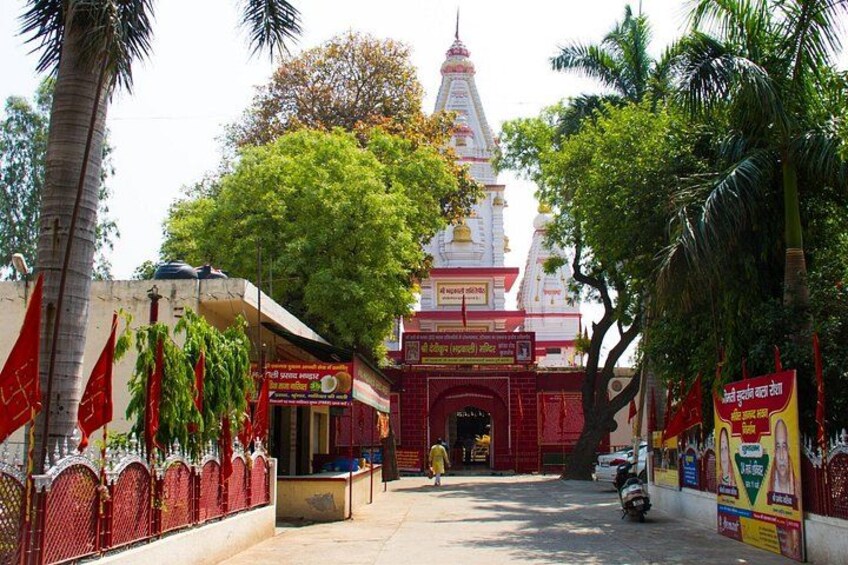 Un templo con entrada roja, palmeras y una aguja blanca. 1