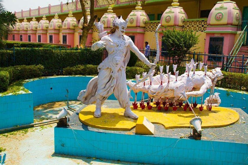 Una estatua de una mujer en una pose dinámica, rodeada de figuras más pequeñas dispuestas en círculo. 4