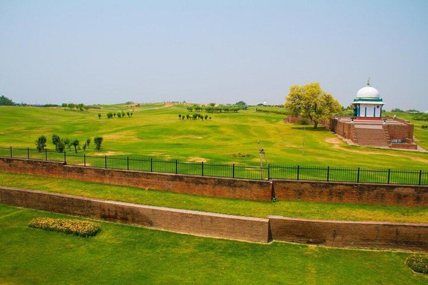 Un campo de golf con un edificio de forma abovedada y una pared de ladrillo. 3