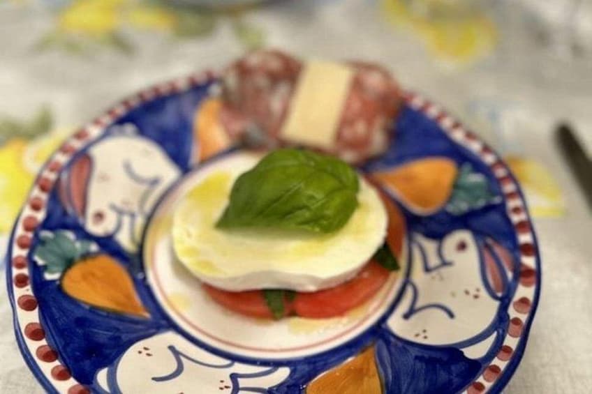 Une assiette avec une tomate, du basilic et du fromage. 2