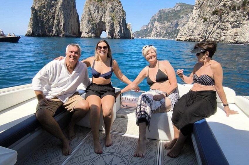 Un grupo de personas en un bote con una costa rocosa al fondo. 1