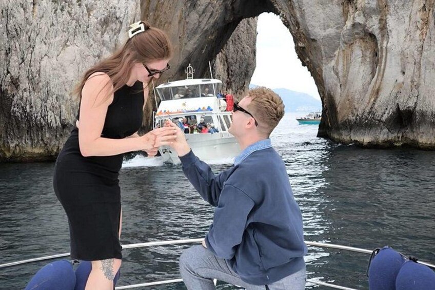 Una pareja en un bote cerca de una gran formación rocosa, con otro bote al fondo. 3