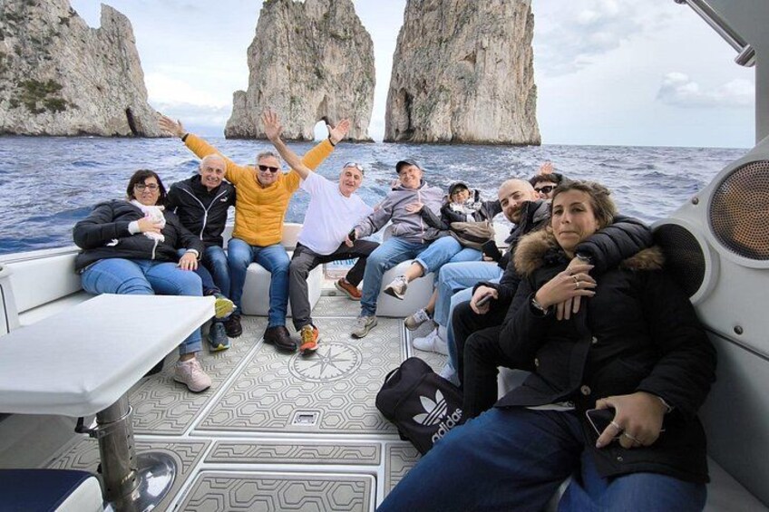 Un grupo de personas en un bote con formaciones rocosas al fondo. 2