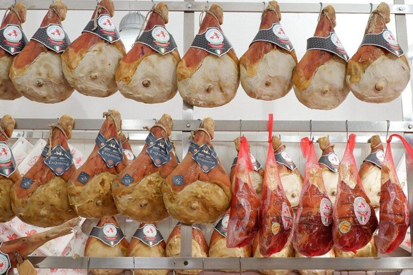 A display of cured meats hanging in a store. 1