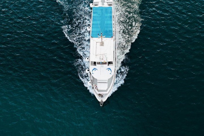 A white yacht with a swimming pool on the deck, moving through the ocean. 2