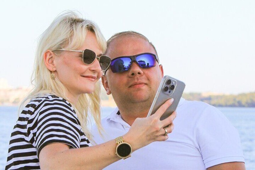 A person holding a smartphone, wearing a striped shirt and a watch. 5