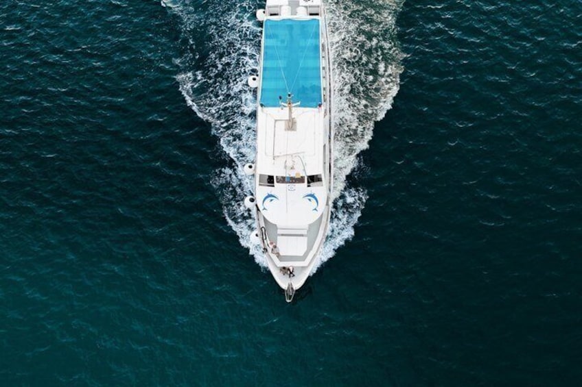 A white yacht with a blue pool on the deck, moving through the ocean. 3