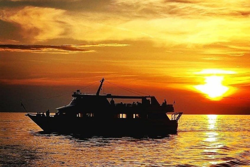 A boat on calm water during sunset with a warm sky. 3