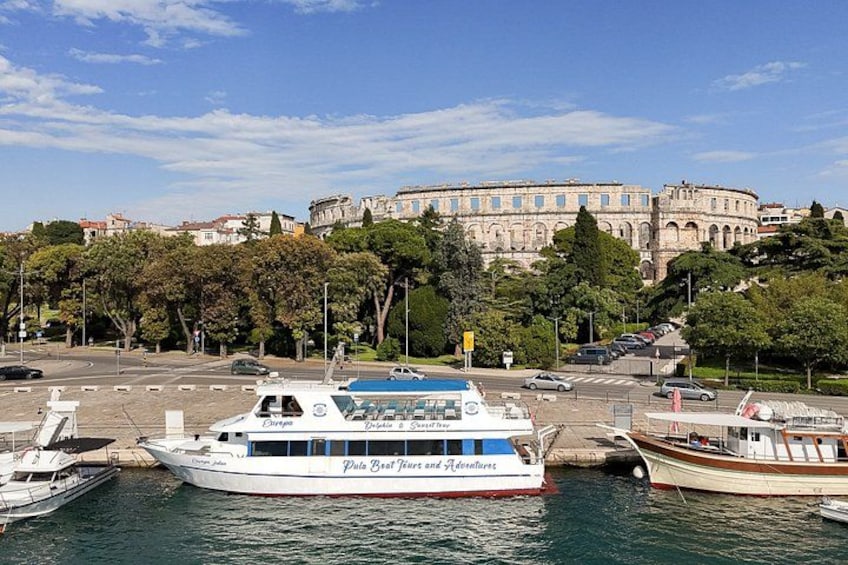 A harbor with boats, a large building in the background, and trees lining the waterfront. 4