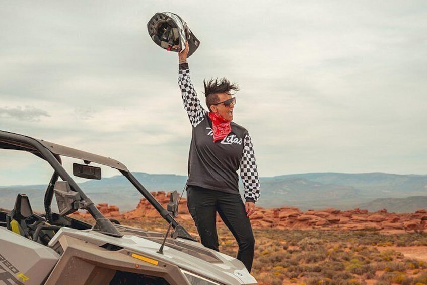 A person standing next to a vehicle in a desert landscape. 4