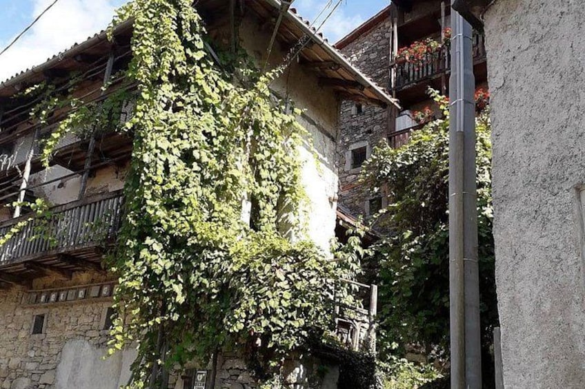 Un edificio con pareti ricoperte d'edera e balconi. 1