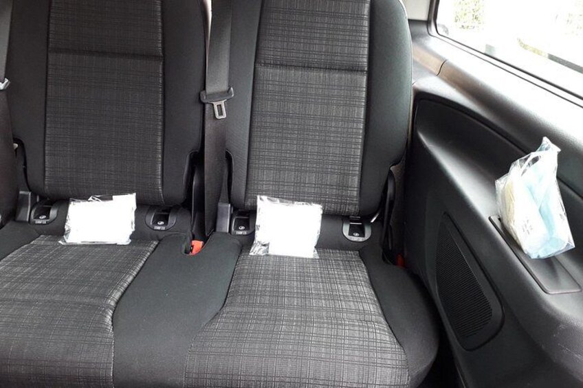 A car's interior with black seats and a window. 3