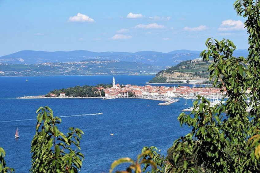 Eine Küstenstadt mit einer markanten Kirche, blauem Meer und Bergen in der Ferne. 3
