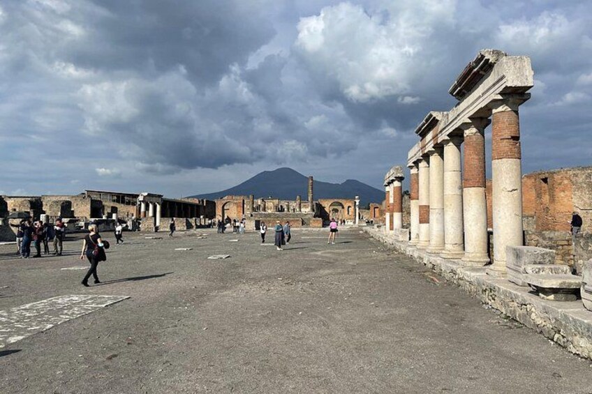 Ancient ruins with columns, a paved area, and a mountain in the background. 5