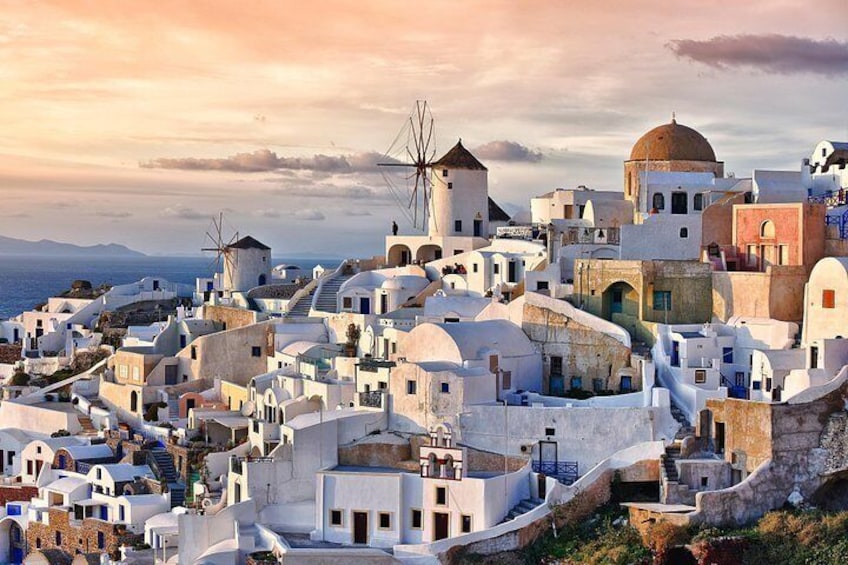 A coastal village with white buildings, windmills, and a dome structure. 1