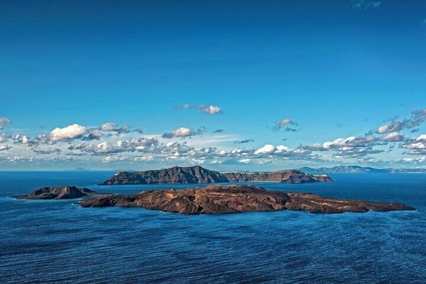 A coastal landscape with rocky outcrops and a clear blue sky. 4