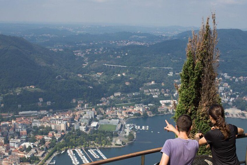 Un paisaje urbano con un río, montañas y un árbol alto. 4