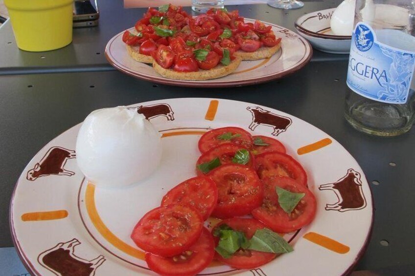 A plate with tomato slices and mozzarella on a table. 1