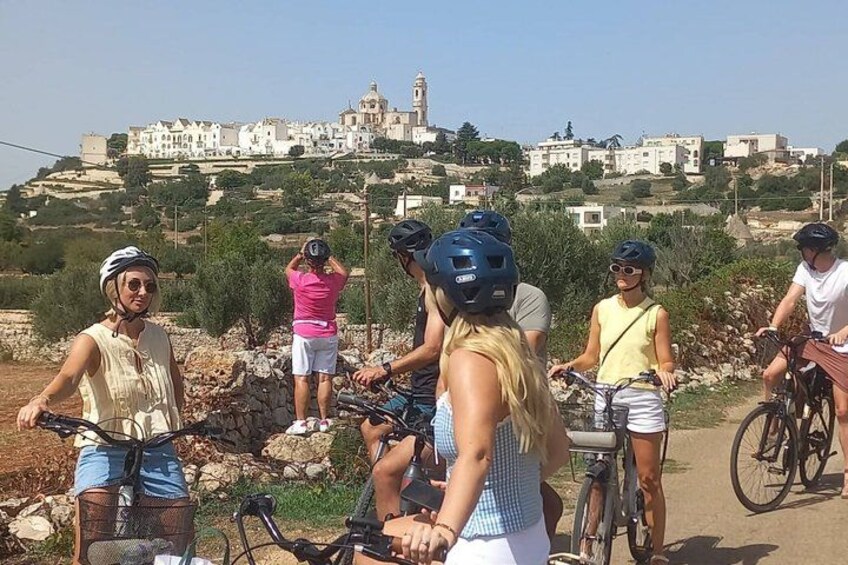 A group of people on bicycles with a coastal town in the background. 1
