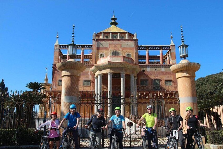 A group of people on bicycles in front of a large, ornate building with columns and a dome. 1