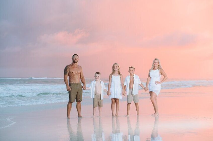 A family of five on a beach at sunset. 3