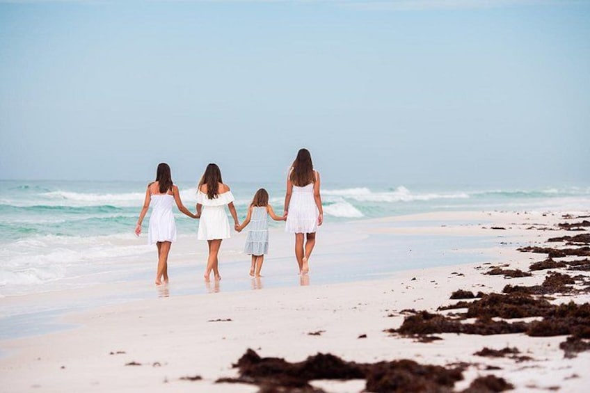 A family walking on a beach with waves in the background. 4